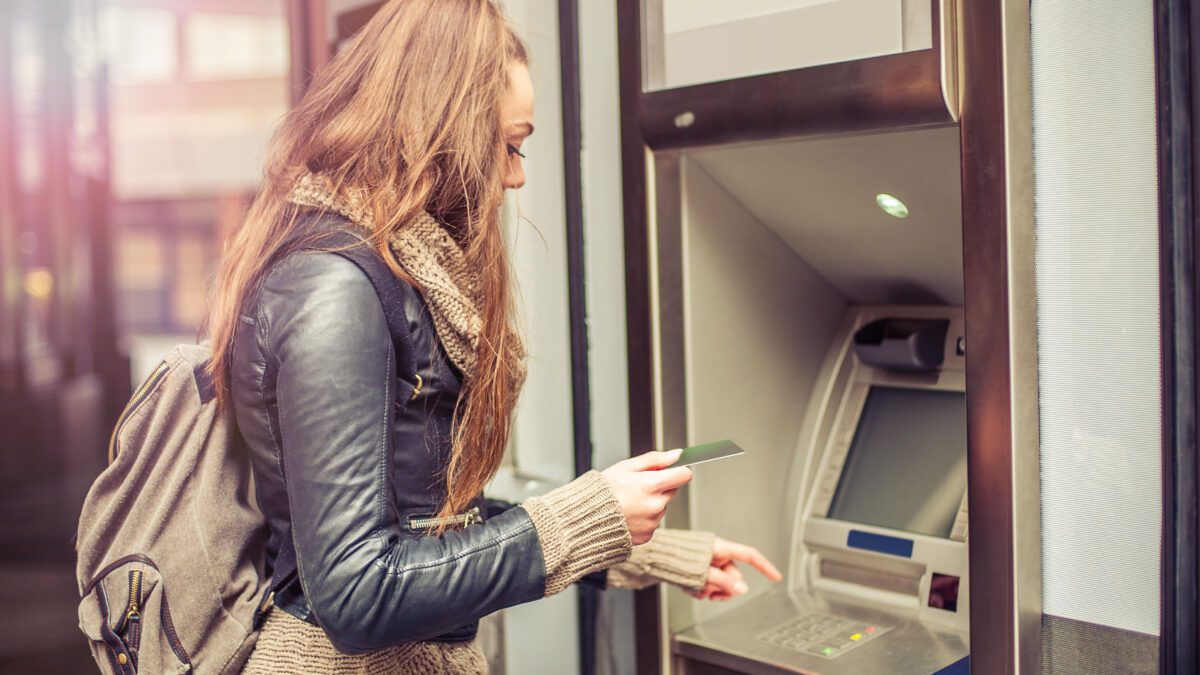 young woman using ATM