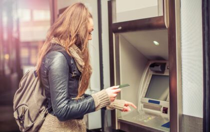 young woman using ATM